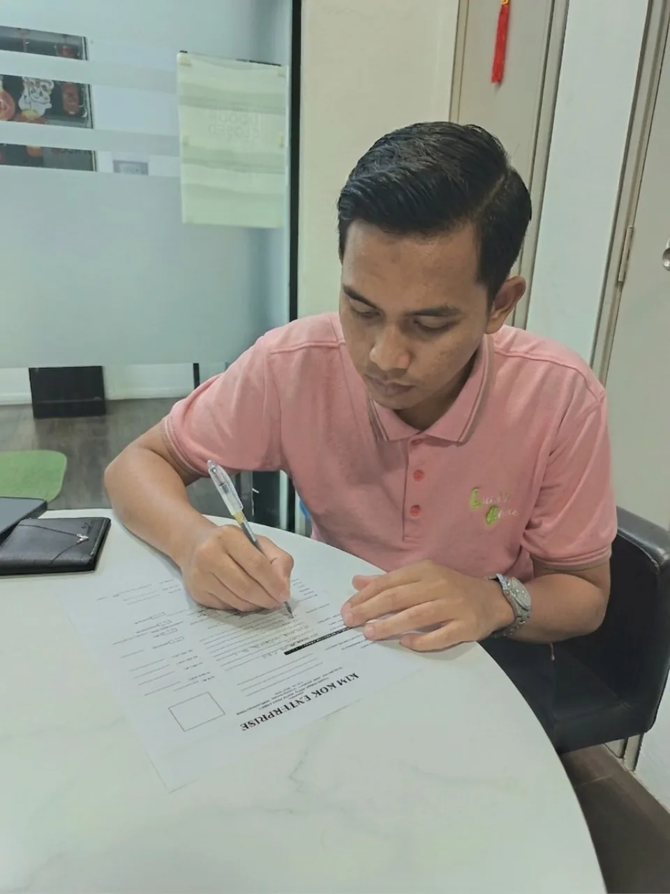 Peminjam menandatangani perjanjian di pejabat Kim Kok Enterprise.